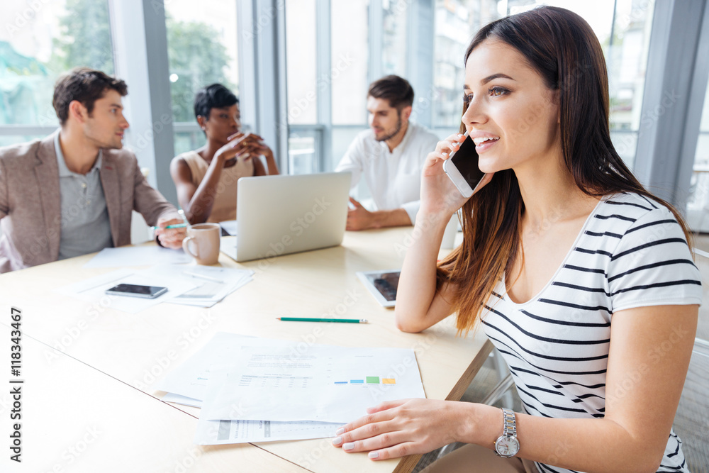 Happy successful woman talking on cell phone at business meeting Happy successful woman talking on cell phone at business meeting
