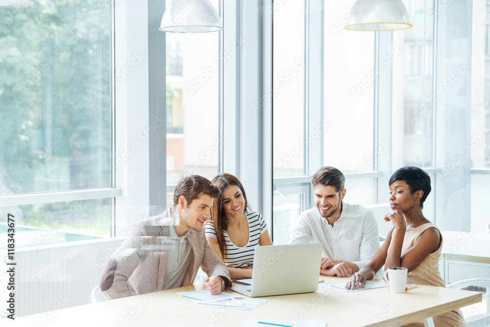 Fototapeta premium Happy business team working with laptop together in office