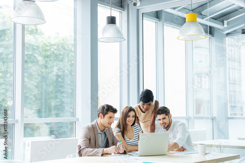 Business people creating presentation and using laptop together in office