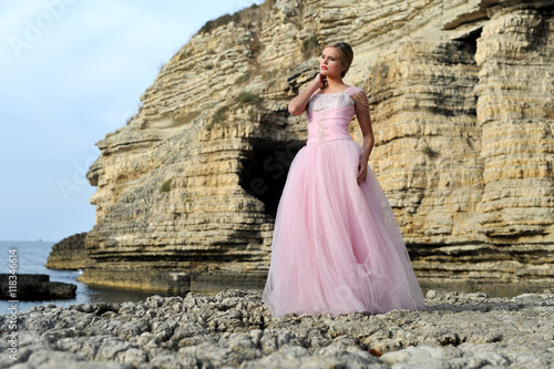 young blonde women wearing pink engagement dress on the nature