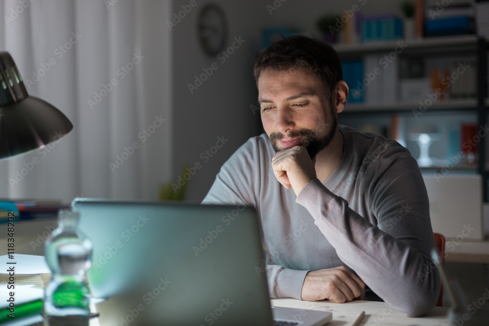 Man using a laptop late at night Man using a laptop late at night