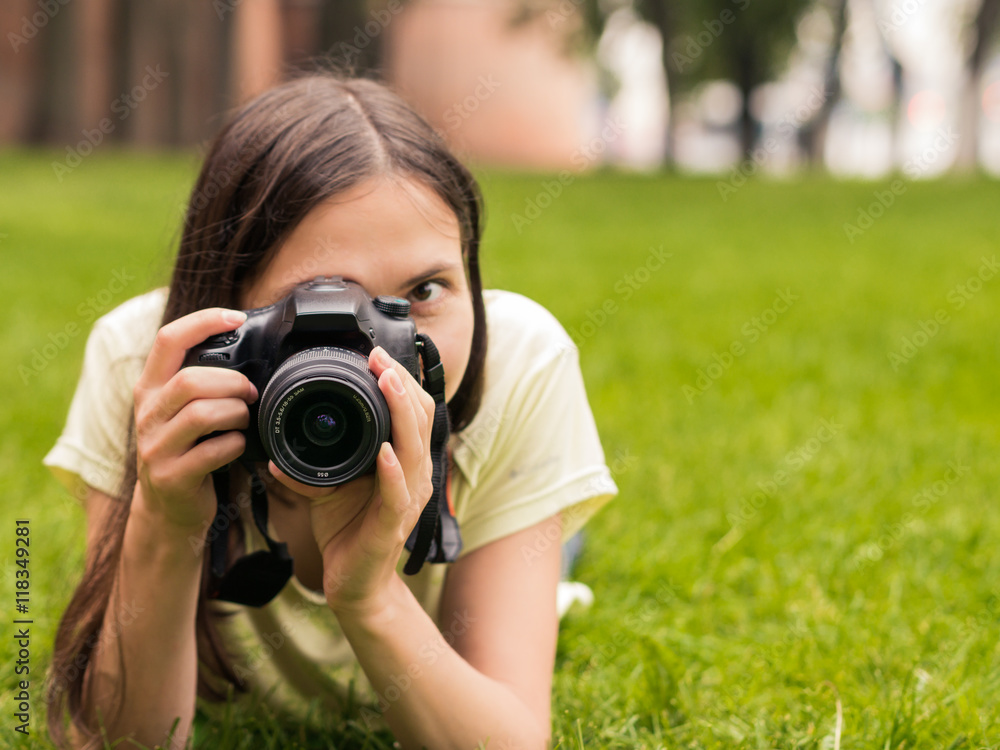 girl with camera lie down on grass girl with camera lie down on grass