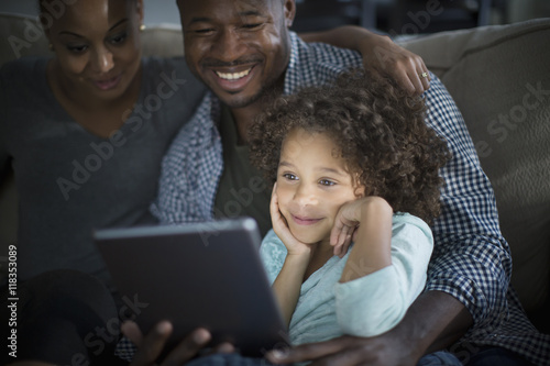 Family using digital tablet on sofa