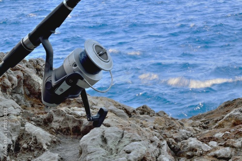 Una canna da pesca appoggiata sugli scogli  photo