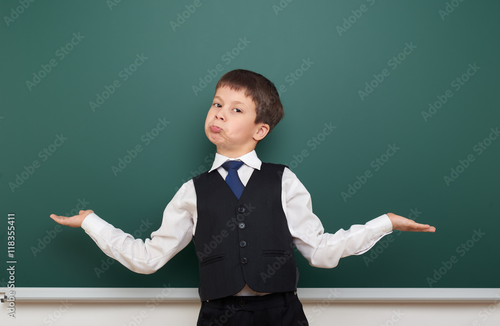 school student boy posing at the clean blackboard and open arms, grimacing and emotions, dressed in a black suit, education concept, studio photo school student boy posing at the clean blackboard and open arms, grimacing and emotions, dressed in a black suit, education concept, studio photo