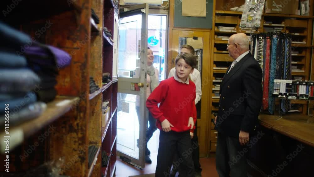 Mother shopping with her children in school uniform supply store Mother shopping with her children in school uniform supply store