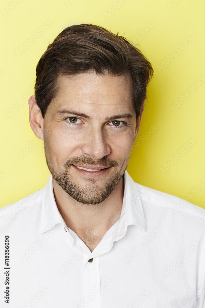 Portrait of smiling man on yellow background