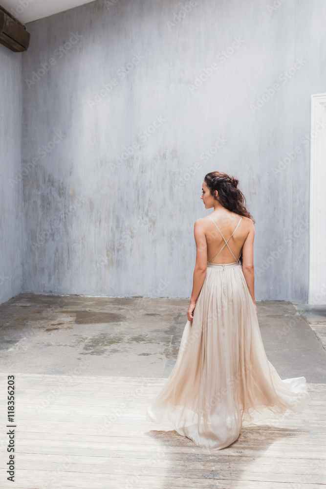 Bride with long black hair in the studio, a photo from the back