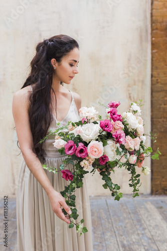 Beautiful bride looking at amazing wedding flowers