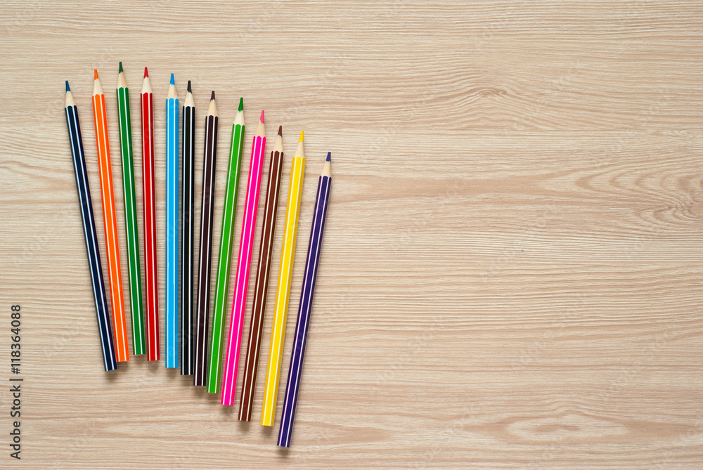Fototapeta premium Pencils, crayons and notebook on a desk.
