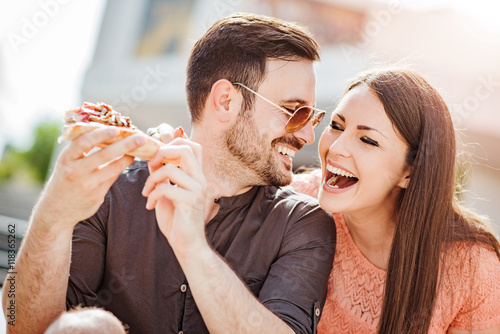 Couple eating pizza snack outdoors
