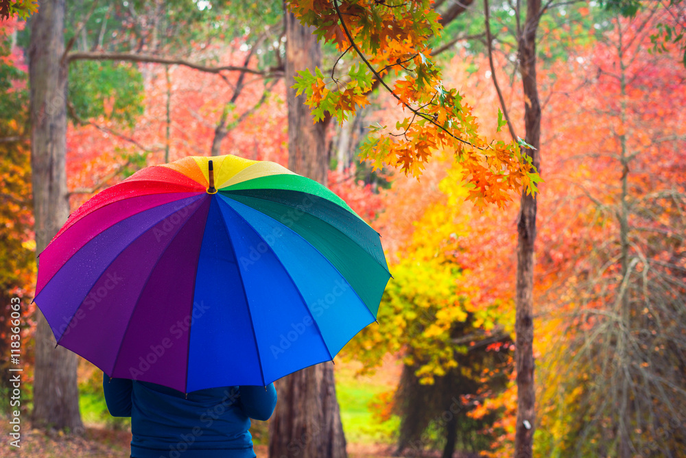 Woman standing under colorful umbrella