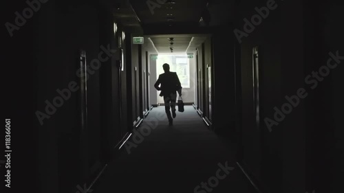 Wallpaper Mural Silhouette of businessman running through dark corridor in the office building and throwing away documents on his way Torontodigital.ca
