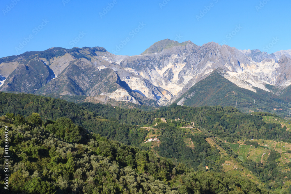 Panoramic view of the Alpi Apuane mountain chain with white marble quarries in Tuscany, Italy.