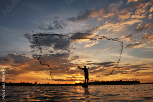 The siluate  fisherman casting a nets into the water during on sunset,Nongkhai Thailand photo