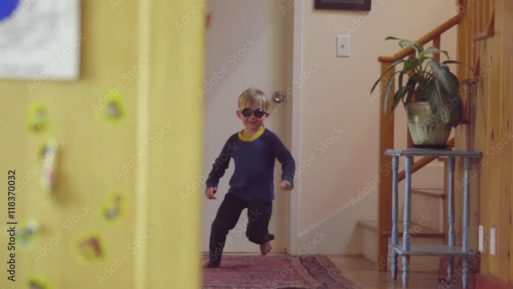 Silly young Caucasian boy runs down the stairs of home wearing swim goggles and pajamas, into his mother's arms sitting on the couch Silly young Caucasian boy runs down the stairs of home wearing swim goggles and pajamas, into his mother's arms sitting on the couch