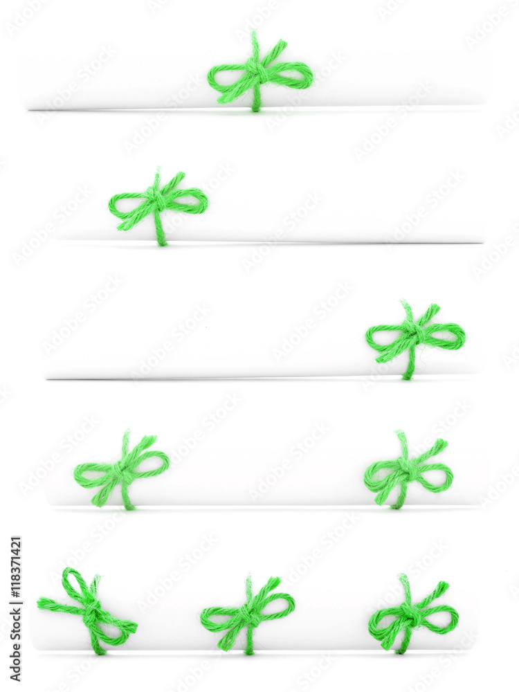 White paper rolls tied with green cords and bows collection