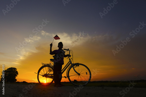 independence Day concept - Silhouette of young local boy on paddy field