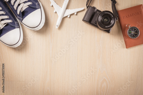 Flat lay of travel planning and equipment necessary on wooden floor background - Holiday travel concept.