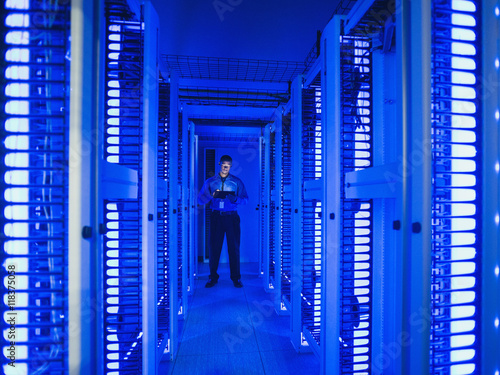 Black businessman using digital tablet in server room
