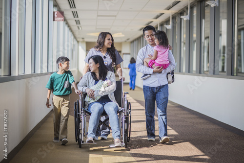 Nurse with patient and family in hospital hallway