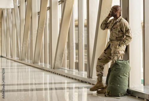 African American soldier talking on cell phone in airport photo