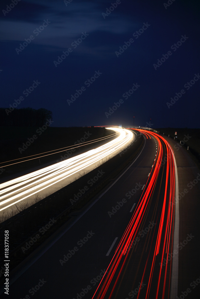 Winding Motorway at night, long exposure of headlights and taillights in blurred motion