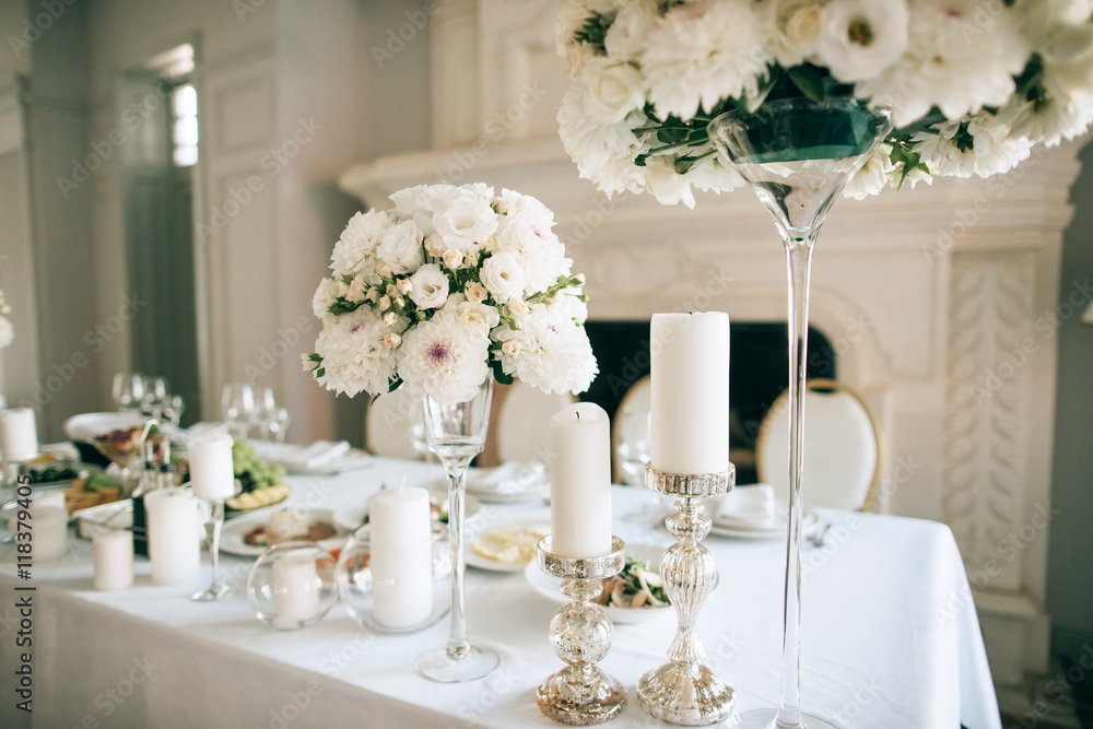 Table decor with white flowers  and candles for an event party or wedding reception - obrazy, fototapety, plakaty 
