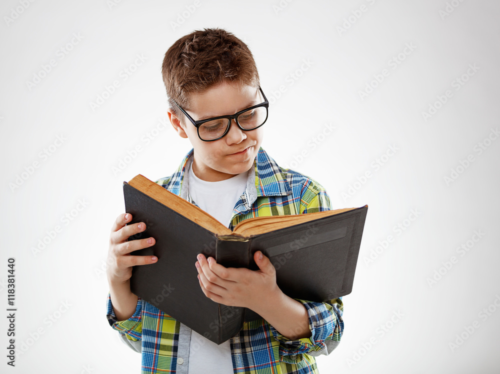 child boy teenager with glasses reding book on gray background child boy teenager with glasses reding book on gray background