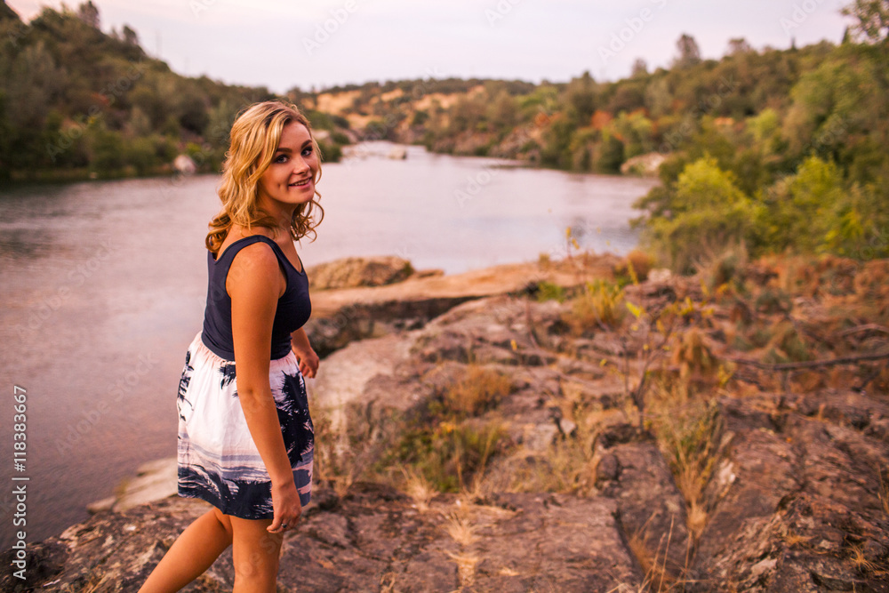 Caucasian teenage girl walking on riverbank Caucasian teenage girl walking on riverbank