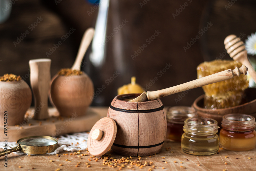 Honey background. Natural honey comb, glass jarand wooden bowls. On wooden rustic table. Soft focus Honey background. Natural honey comb, glass jarand wooden bowls. On wooden rustic table. Soft focus