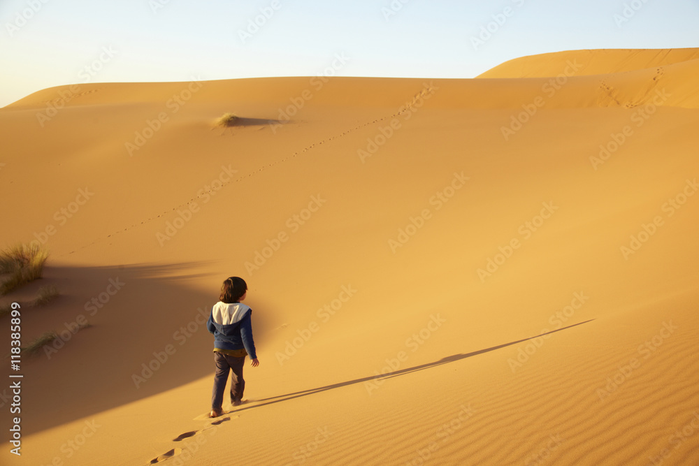 Mixed race boy walking in desert Mixed race boy walking in desert