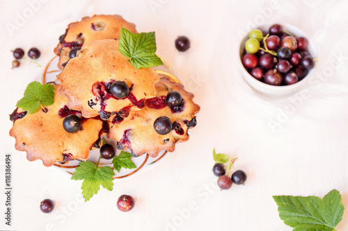 Muffins with black currants on white background