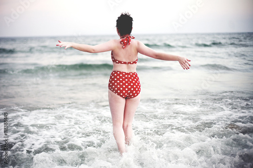 Caucasian teenage girl splashing in ocean waves photo