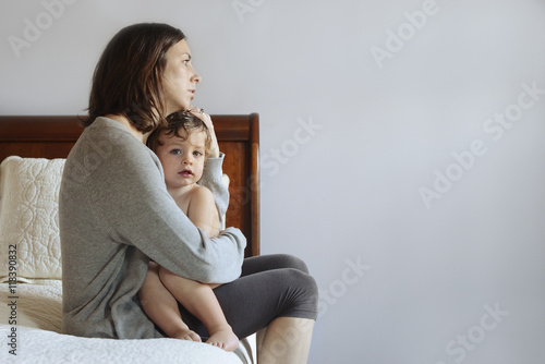 Caucasian mother hugging son on bed photo