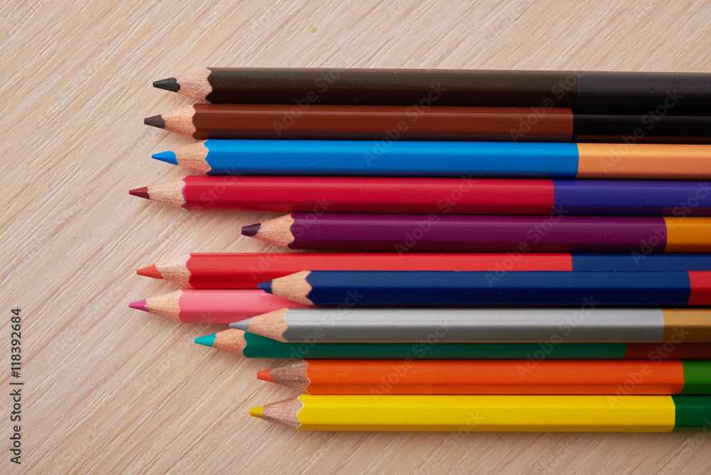 colored pencils in a wooden school desk colored pencils in a wooden school desk