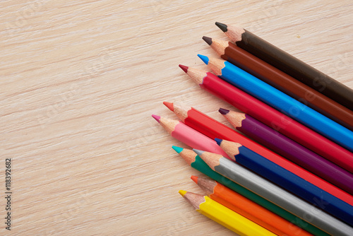 colored pencils lying on a wooden desk
