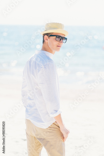 Good looking man in a hat sitting at the seashore