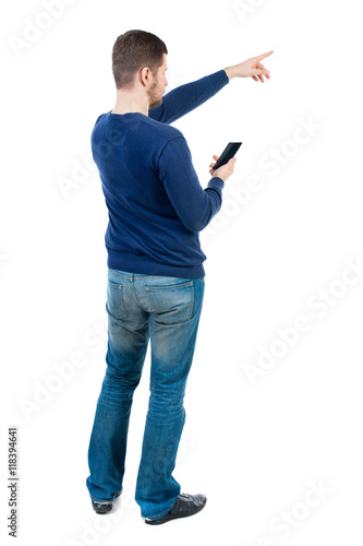 Back view of pointing young men talking on cell phone. Young guy gesture. Rear view people collection. backside view of person. Isolated over white background. bearded man in blue pullover holding