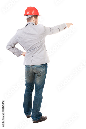 Back view of  pointing young men in helmet. Young guy  gesture. Rear view people collection.  backside view of person.  Isolated over white background. A guy in a gray jacket and an orange helmet © ghoststone