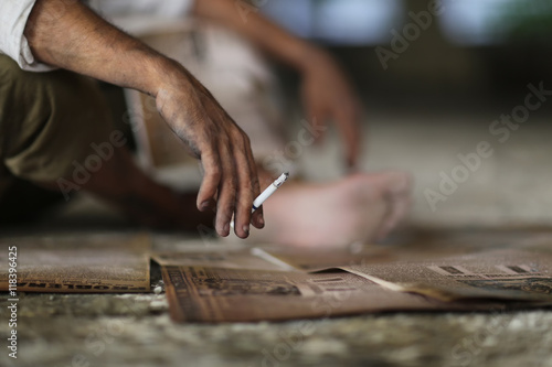 Dirty man hand holding a cigarette with smoke. Working man enjoy