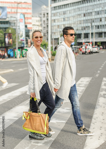 Fashionable couple crossing road at pedestrian zebra crossing © guruXOX