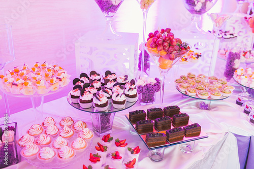 Candy bar, decorated table with sweets and flowers, baked goods