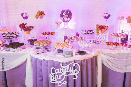 Candy bar, decorated table with sweets and flowers, baked goods