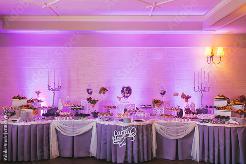 Candy bar, decorated table with sweets and flowers, baked goods