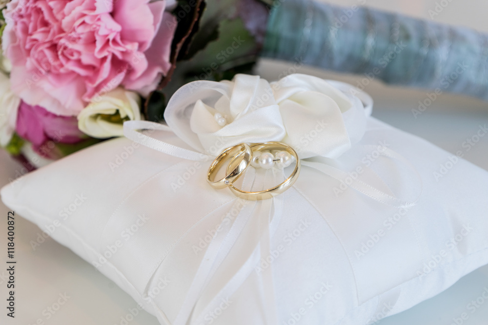 golden wedding rings / white cushion with two golden wedding rings golden wedding rings / white cushion with two golden wedding rings