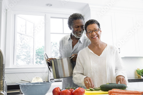 Senior couple cooking in kitchen photo