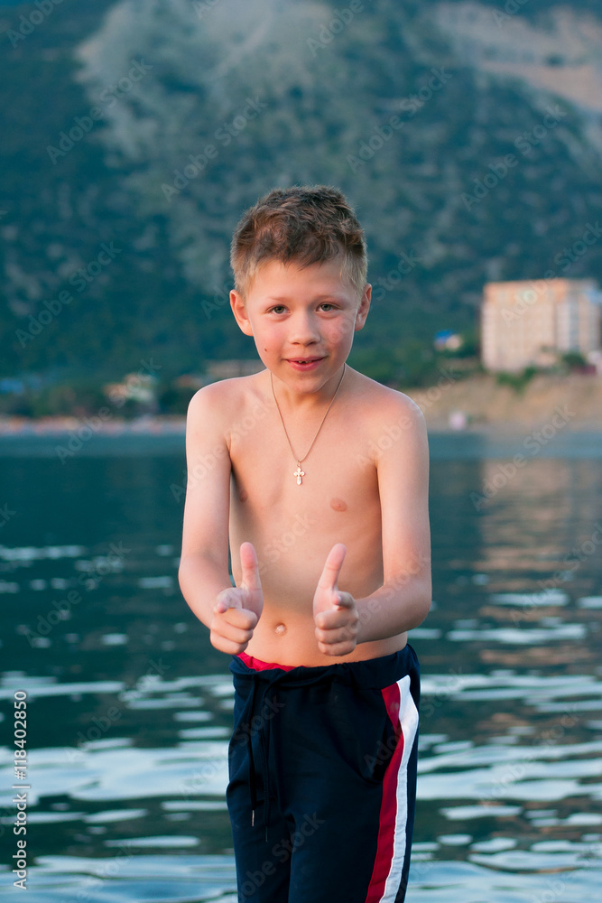 Fototapeta premium Boy on a background of sea and mountains