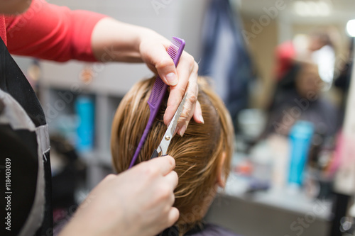 Female hair cutting scissors in beauty salon