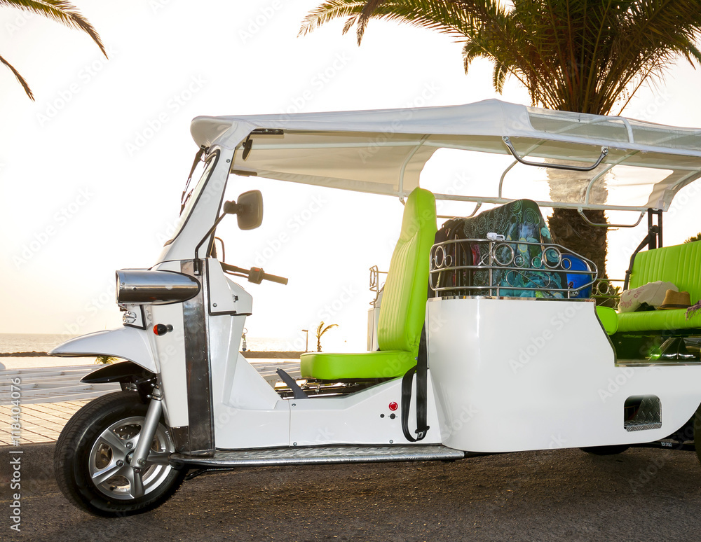 Naklejka premium Tuk tuk taxi on the sunset beach. Tenerife. Canary Islands. Spain